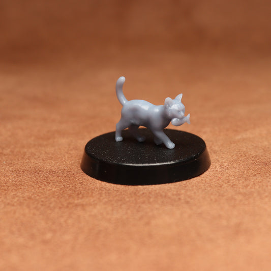 Small gray cat figurine on a black round base against a brown background