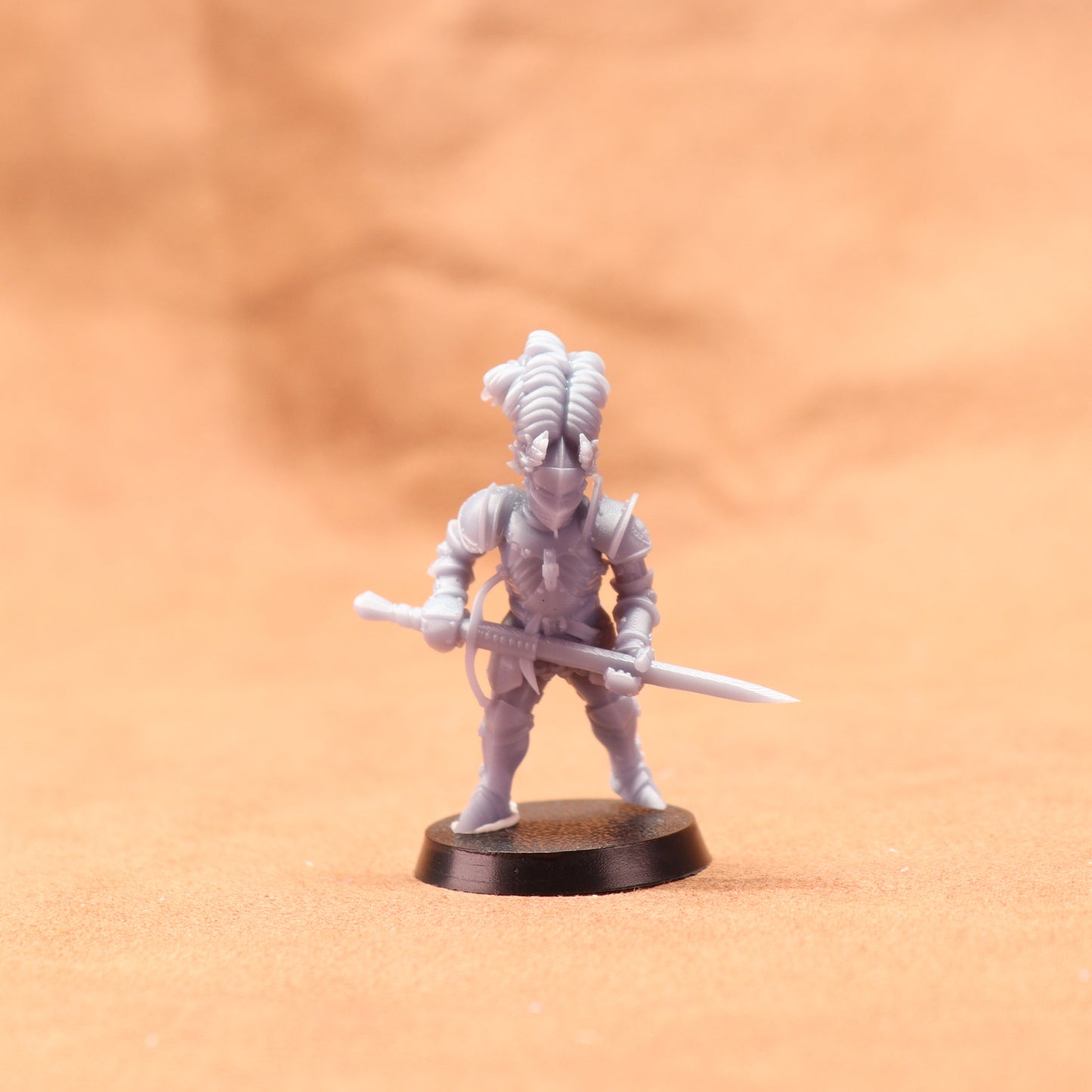 White miniature figure on a black base against an orange background