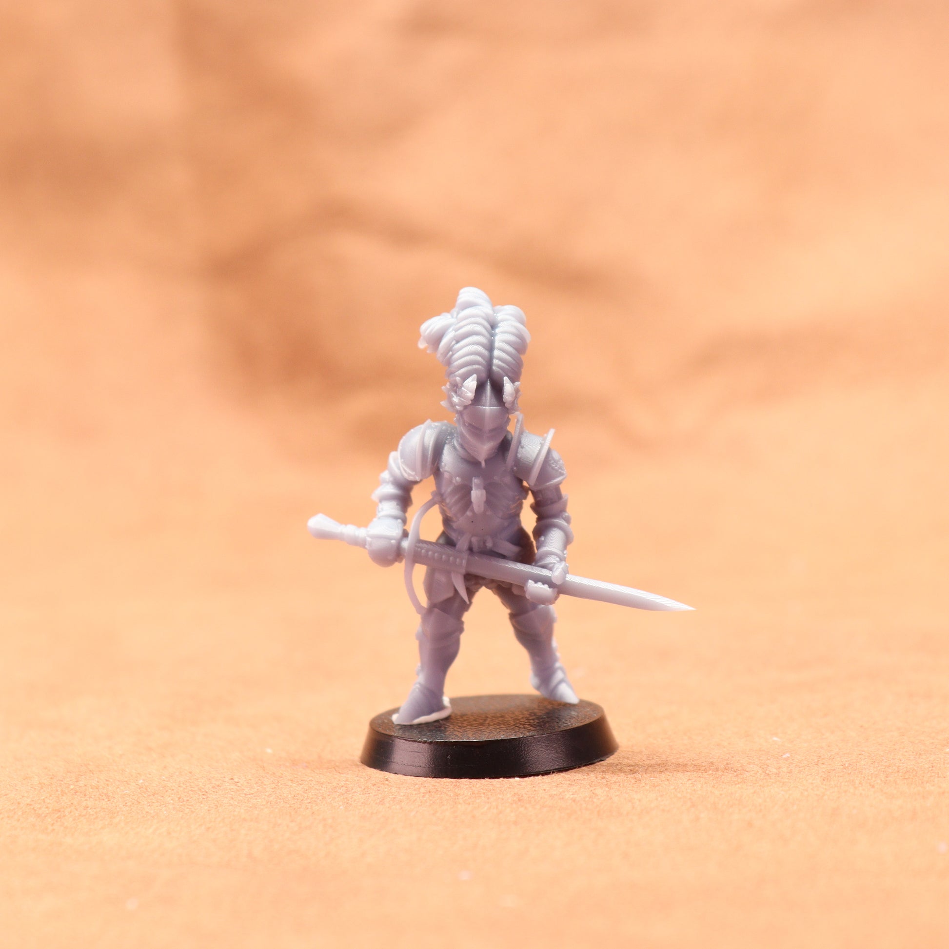 White miniature figure on a black base against an orange background