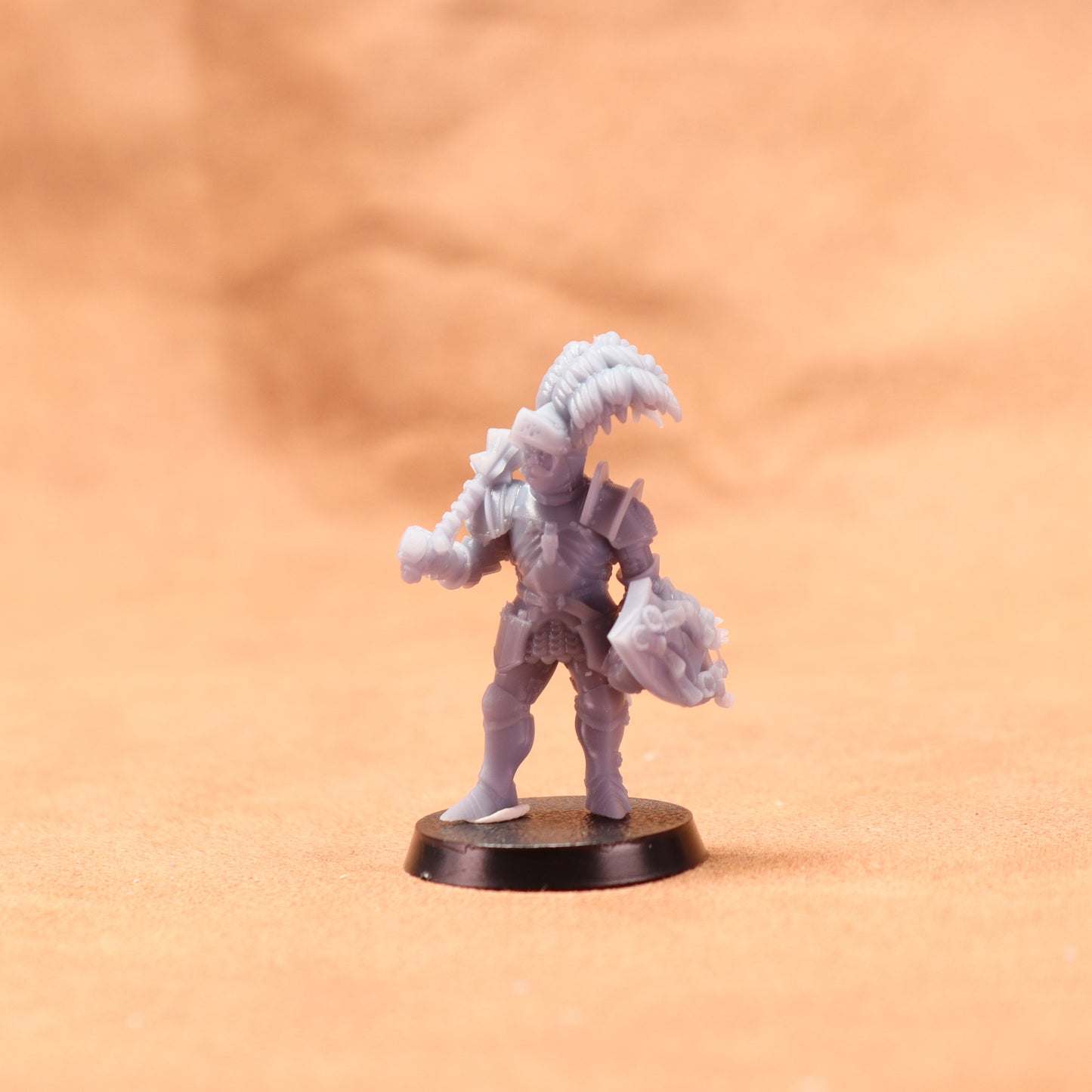 Gray miniature figure on a round base against an orange background