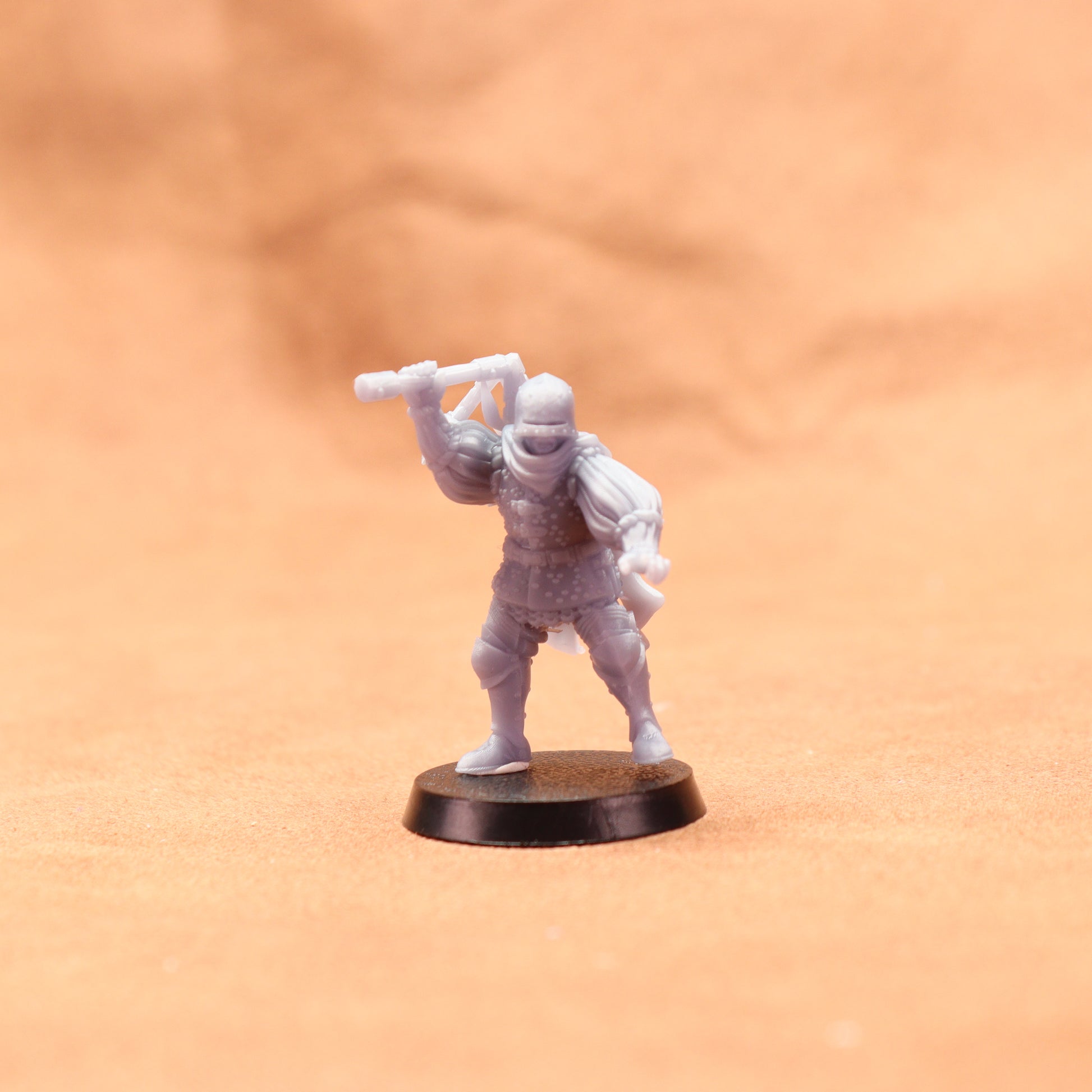White miniature figure on a black base against an orange background