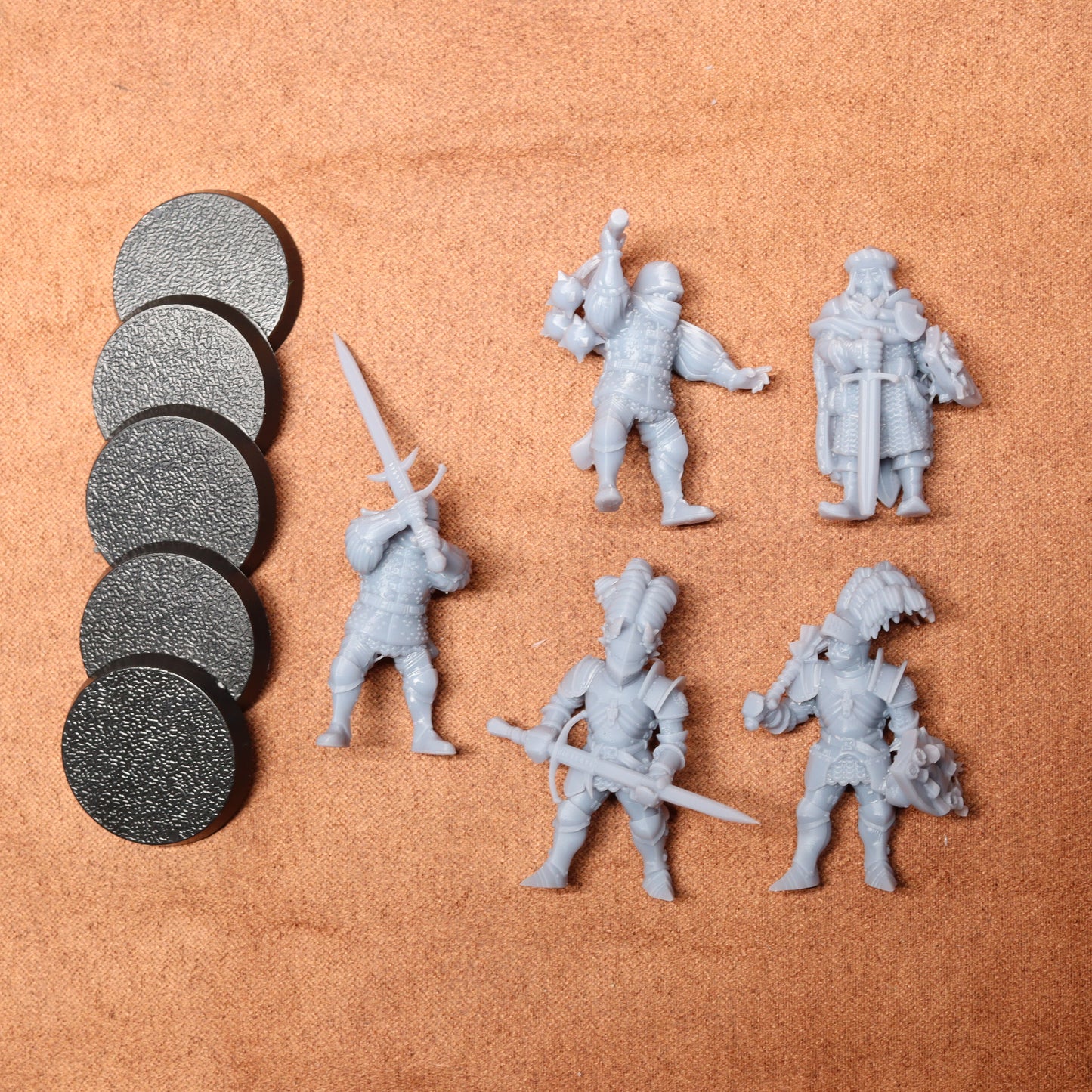 Set of gray miniature figures with weapons on a brown surface