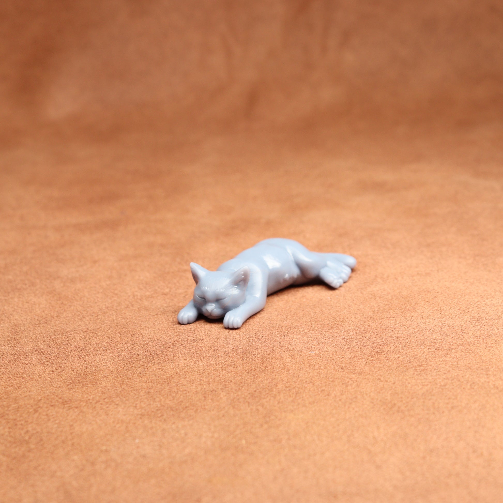 White cat figurine on a brown leather surface