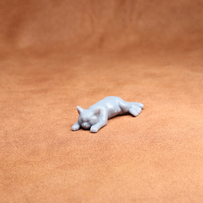 White cat figurine on a brown leather surface