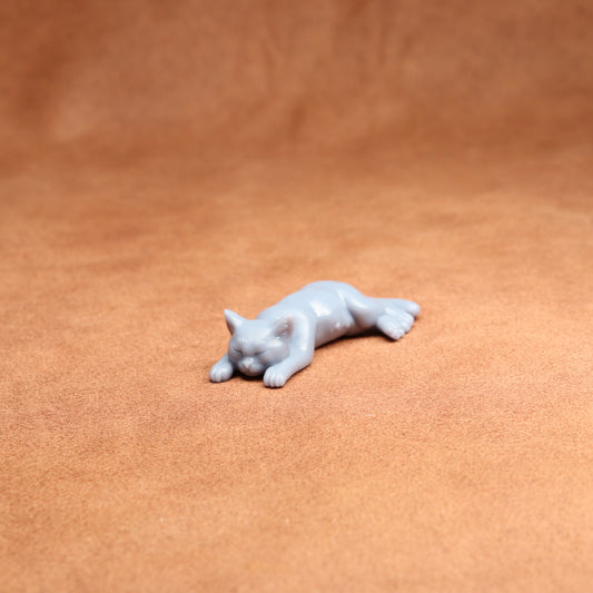 White cat figurine on a brown leather surface