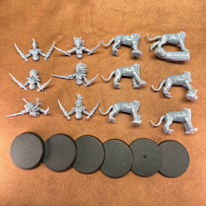 Collection of gray miniature figures and round bases on a brown surface