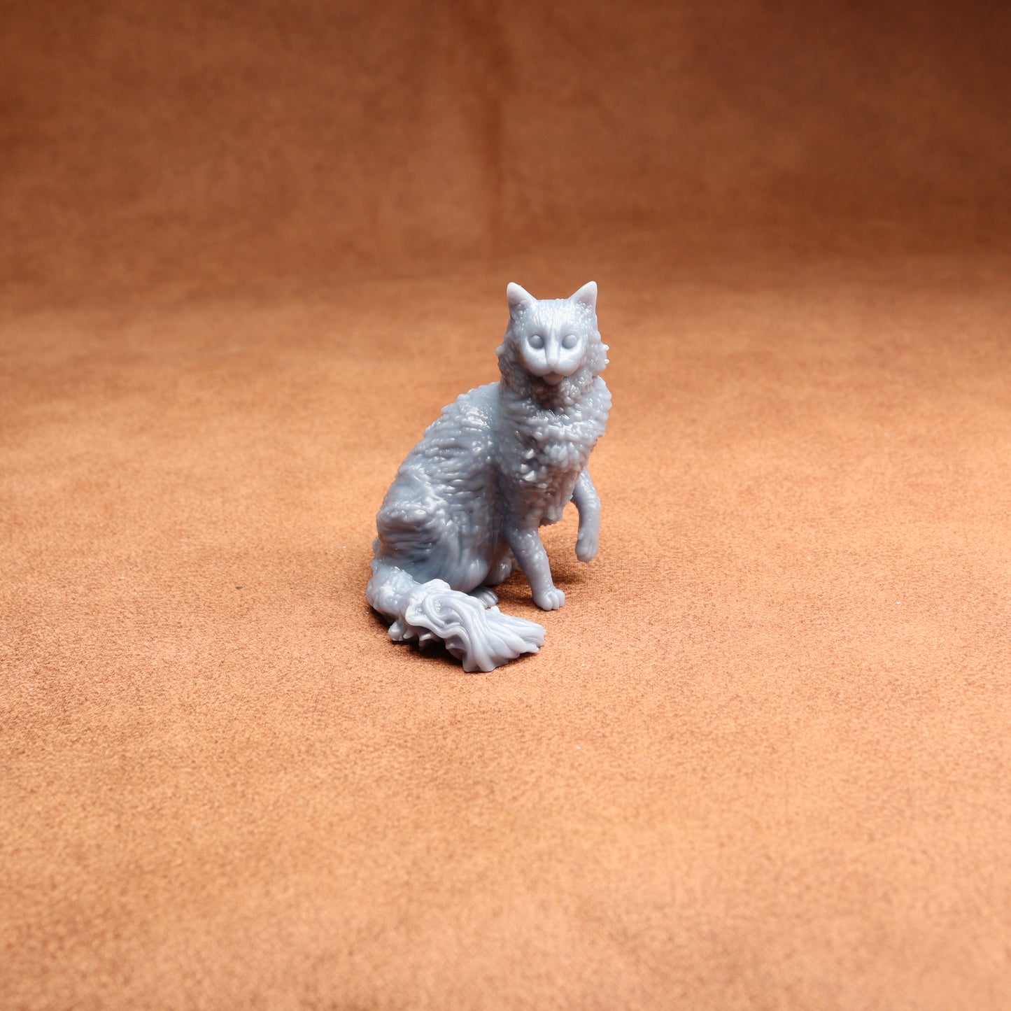 Gray cat figurine on a brown surface
