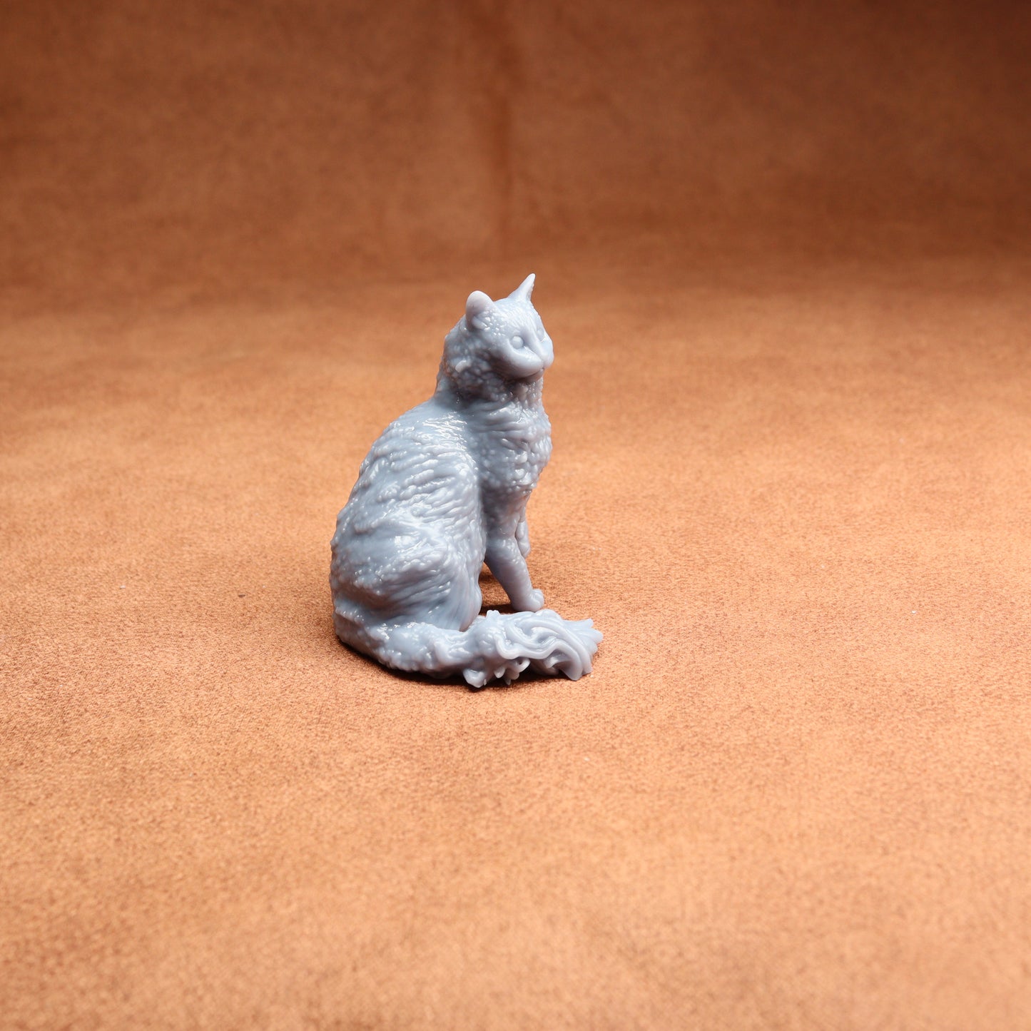 Gray cat figurine on a brown surface