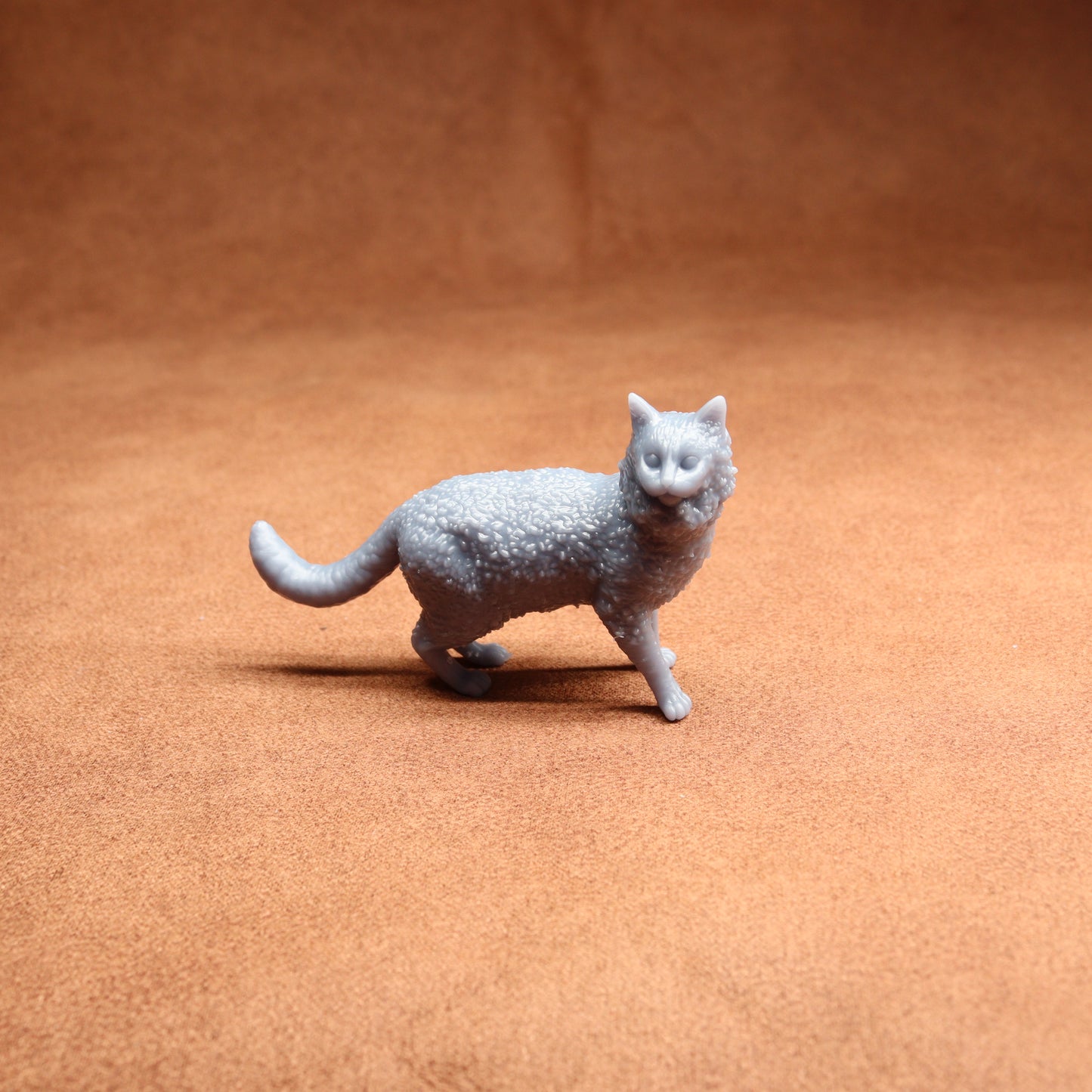 Gray cat figurine on a brown surface