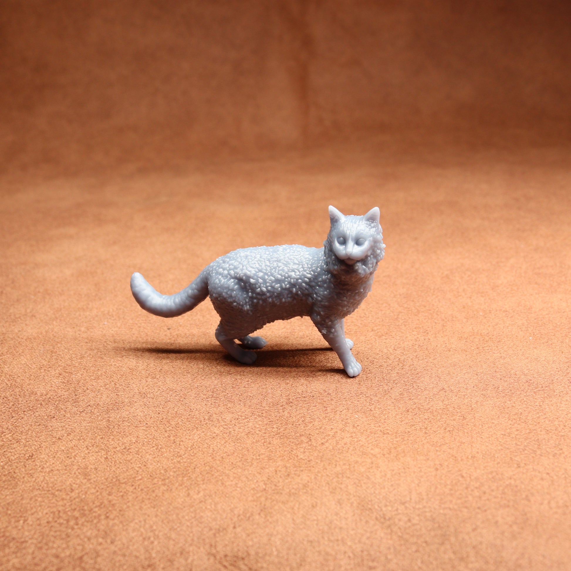 Gray cat figurine on a brown surface
