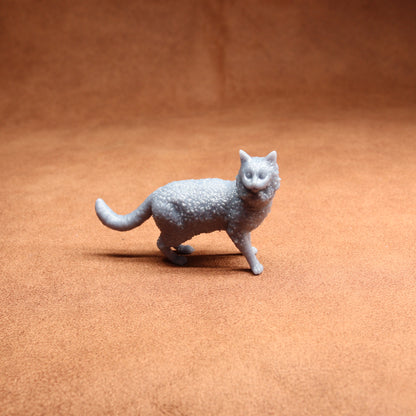 Gray cat figurine on a brown surface
