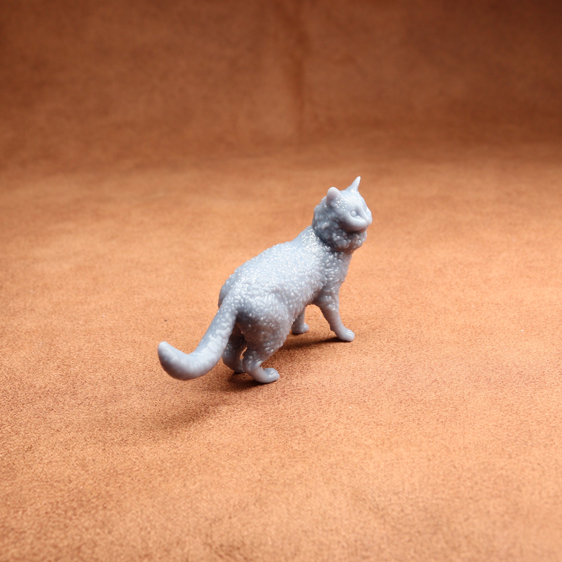 Gray cat figurine on a brown surface