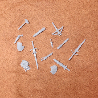 Set of white plastic weapon and armor pieces on a brown surface