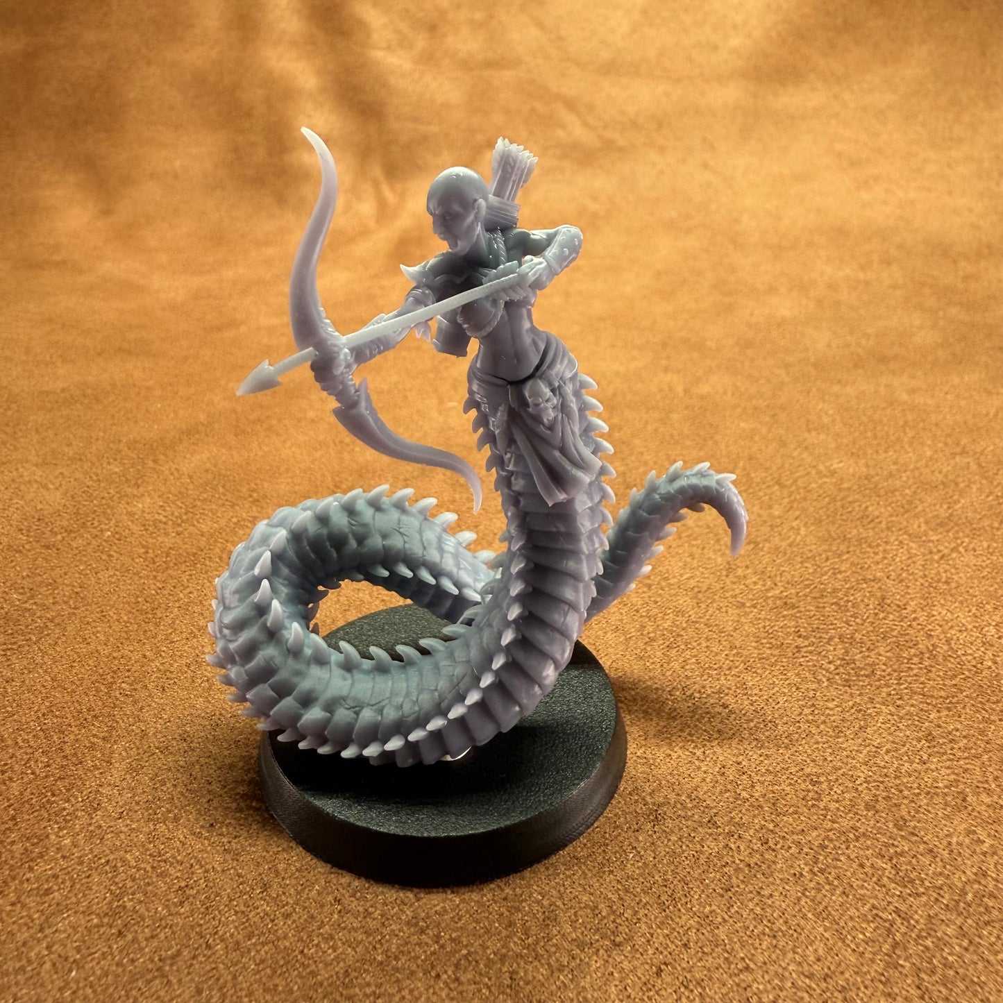 Miniature figurine of a warrior on a dragon-like creature against a brown background