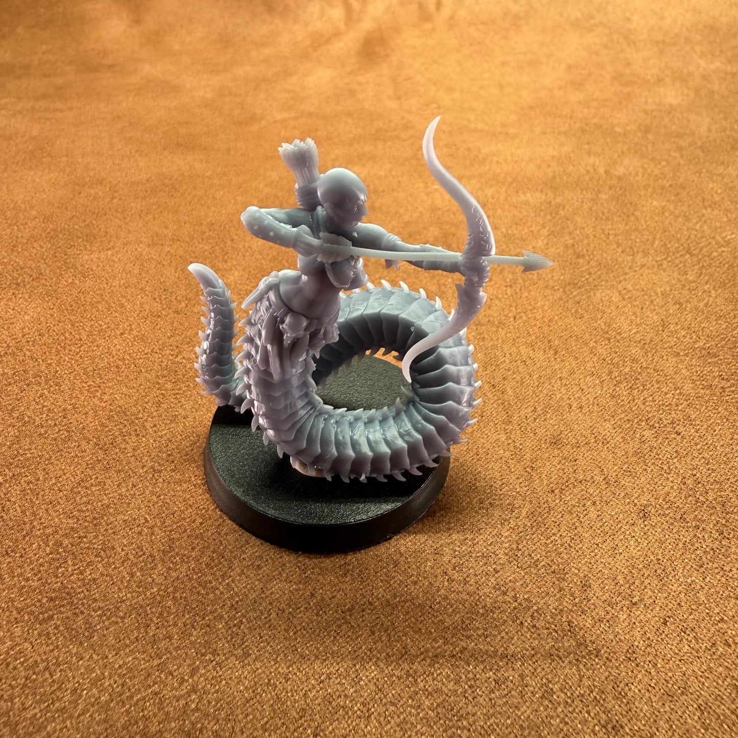 Miniature figurine of a warrior on a dragon-like creature with a brown background