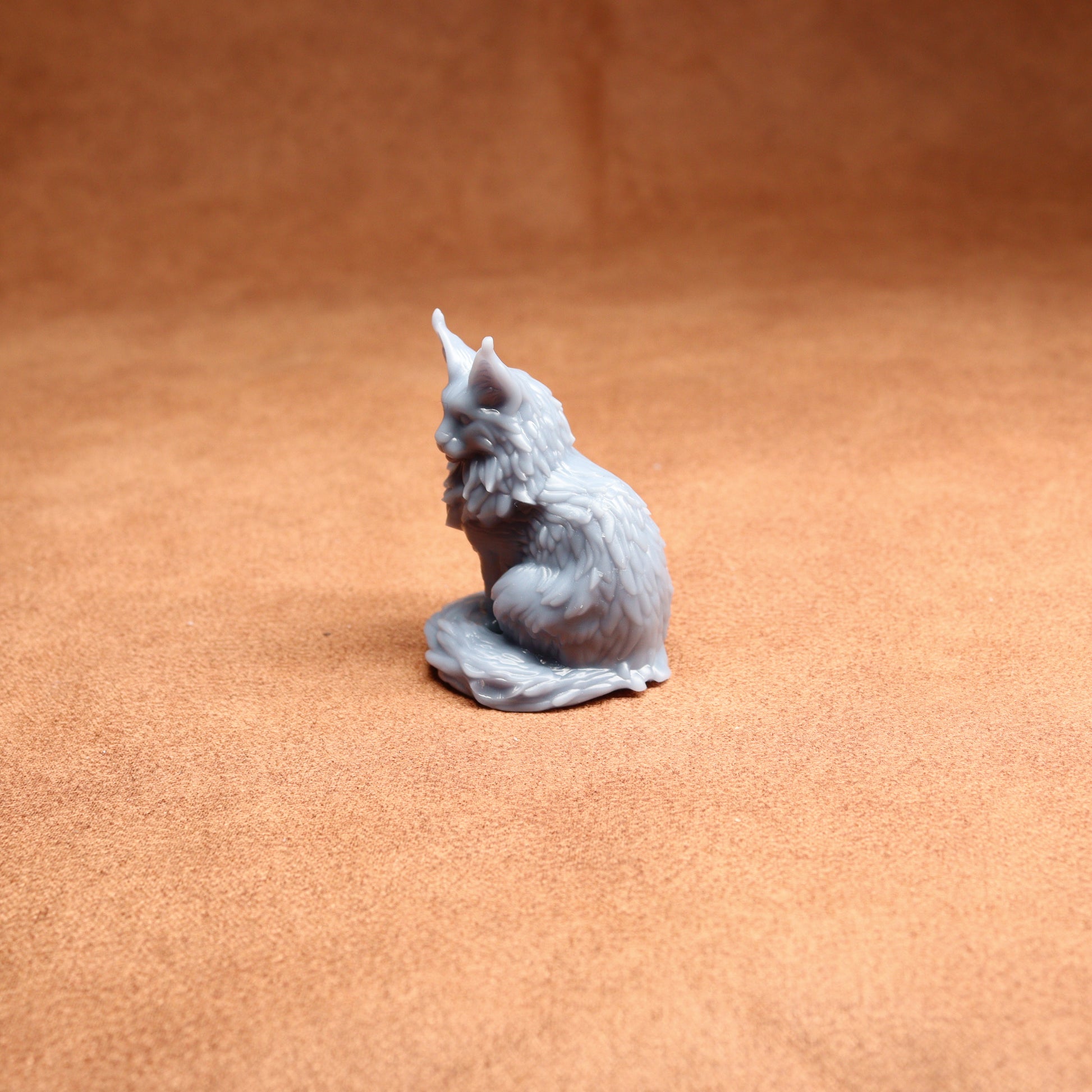 Gray cat figurine on a brown surface