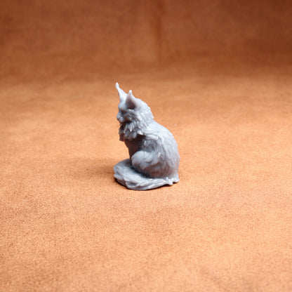 Gray cat figurine on a brown surface