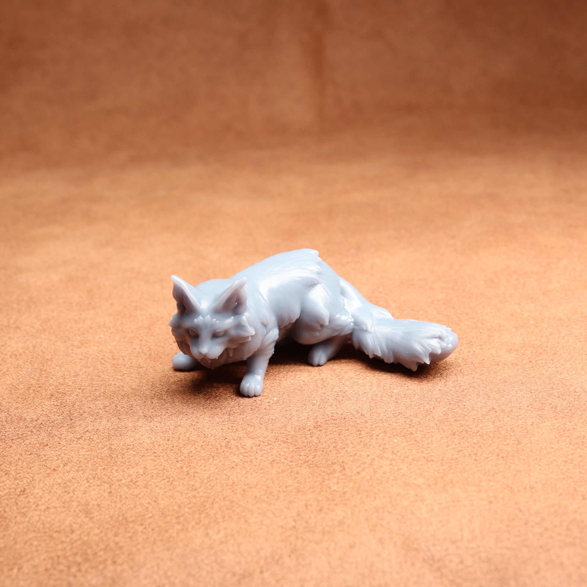 White cat figurine on a brown surface