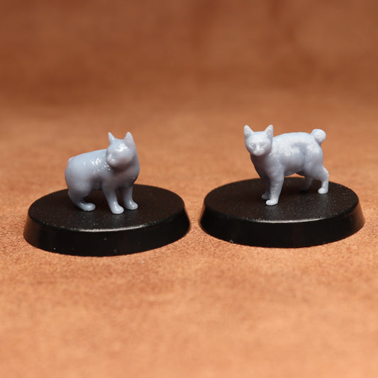 Two white cat figurines on black bases against a brown background