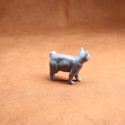 Small gray dog figurine on a brown surface