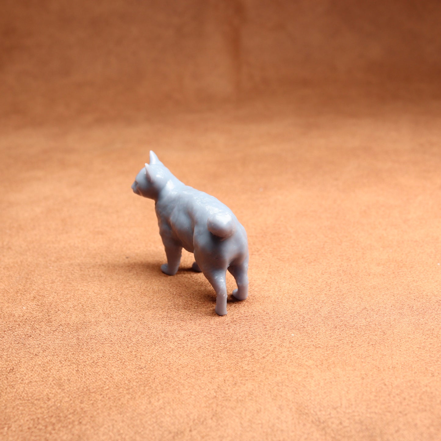 Gray cat figurine on a brown surface