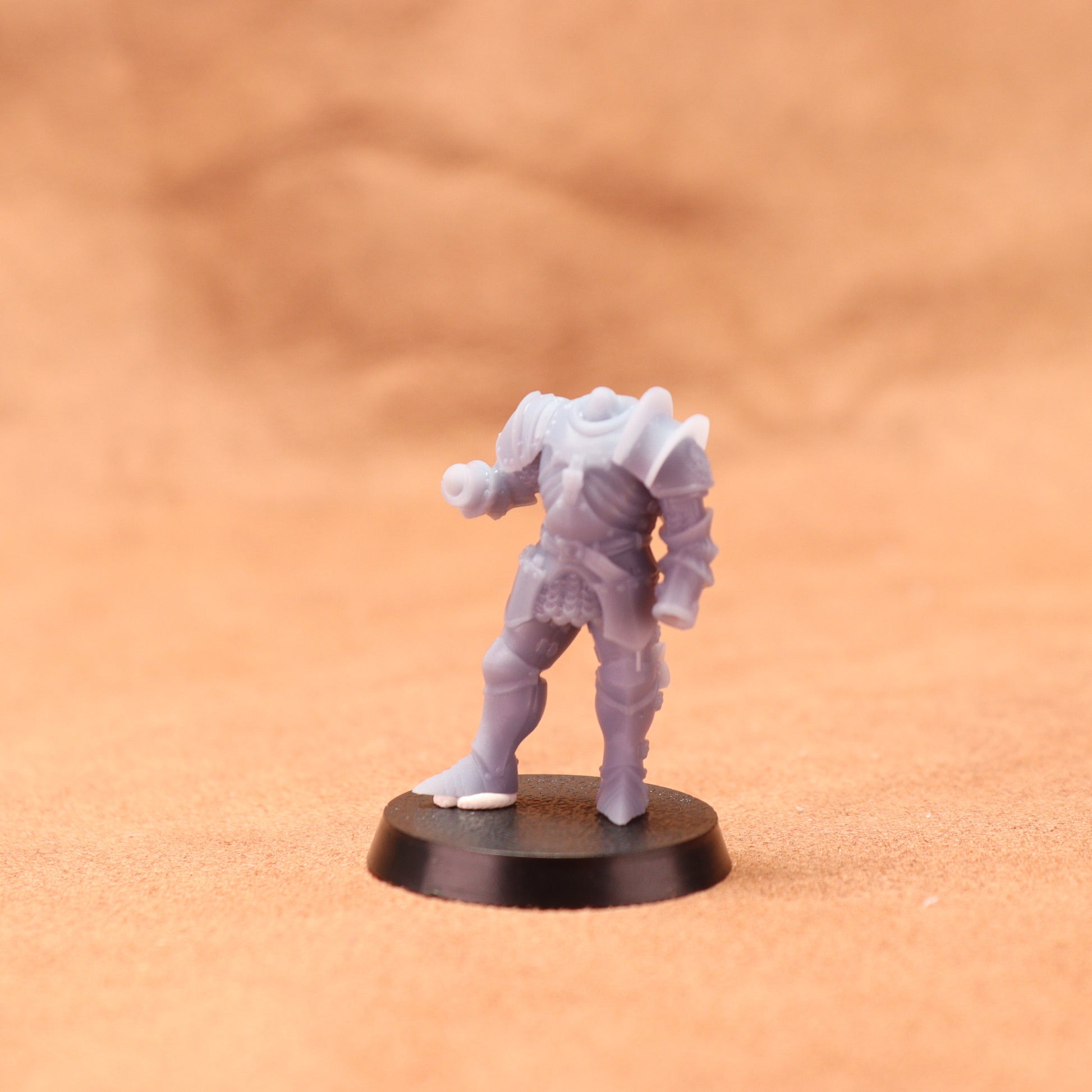 Gray fantasy figurine on a black base against a beige background