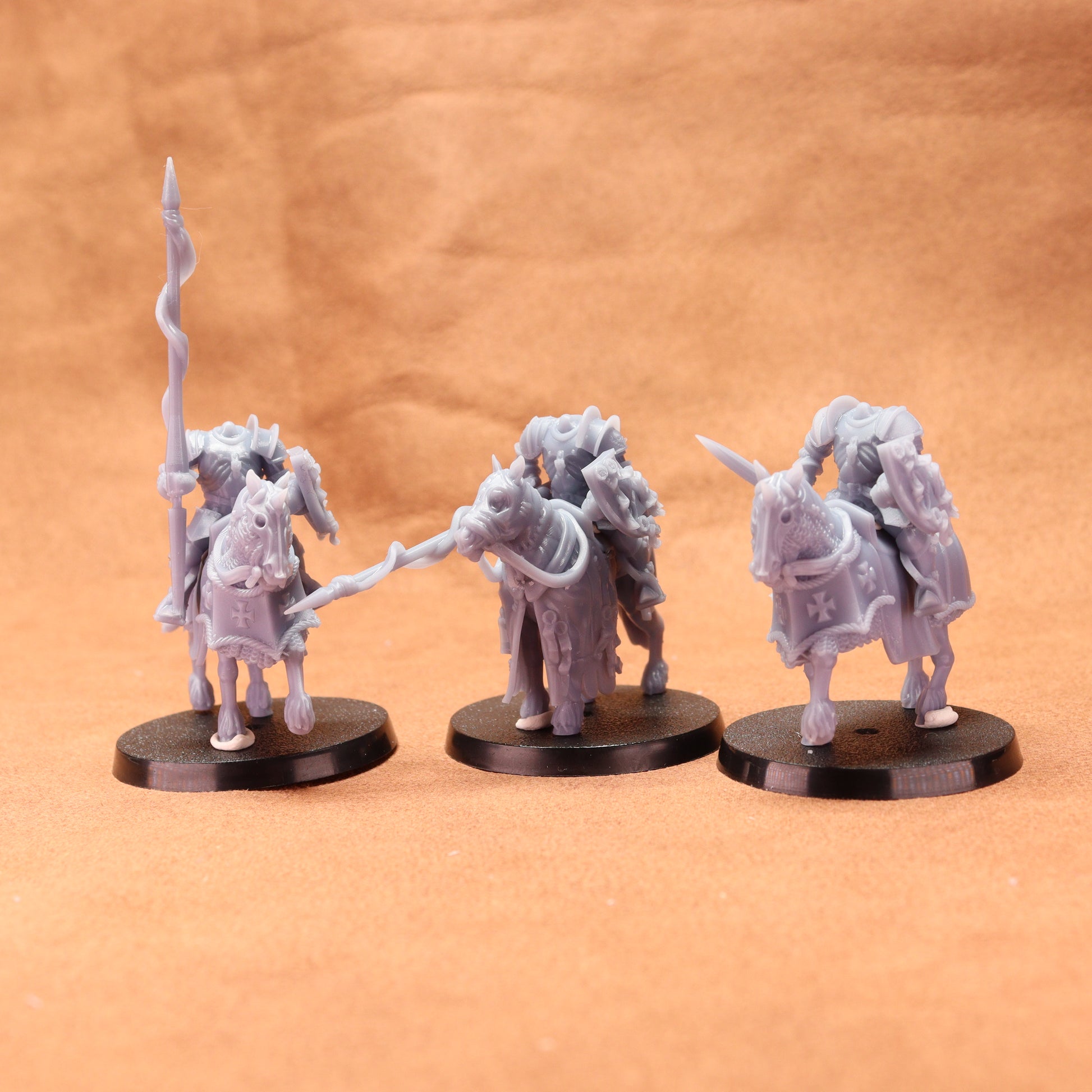 Three fantasy miniature figures on a brown background