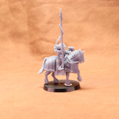 Gray miniature figure of a warrior on horseback with a spear against an orange background