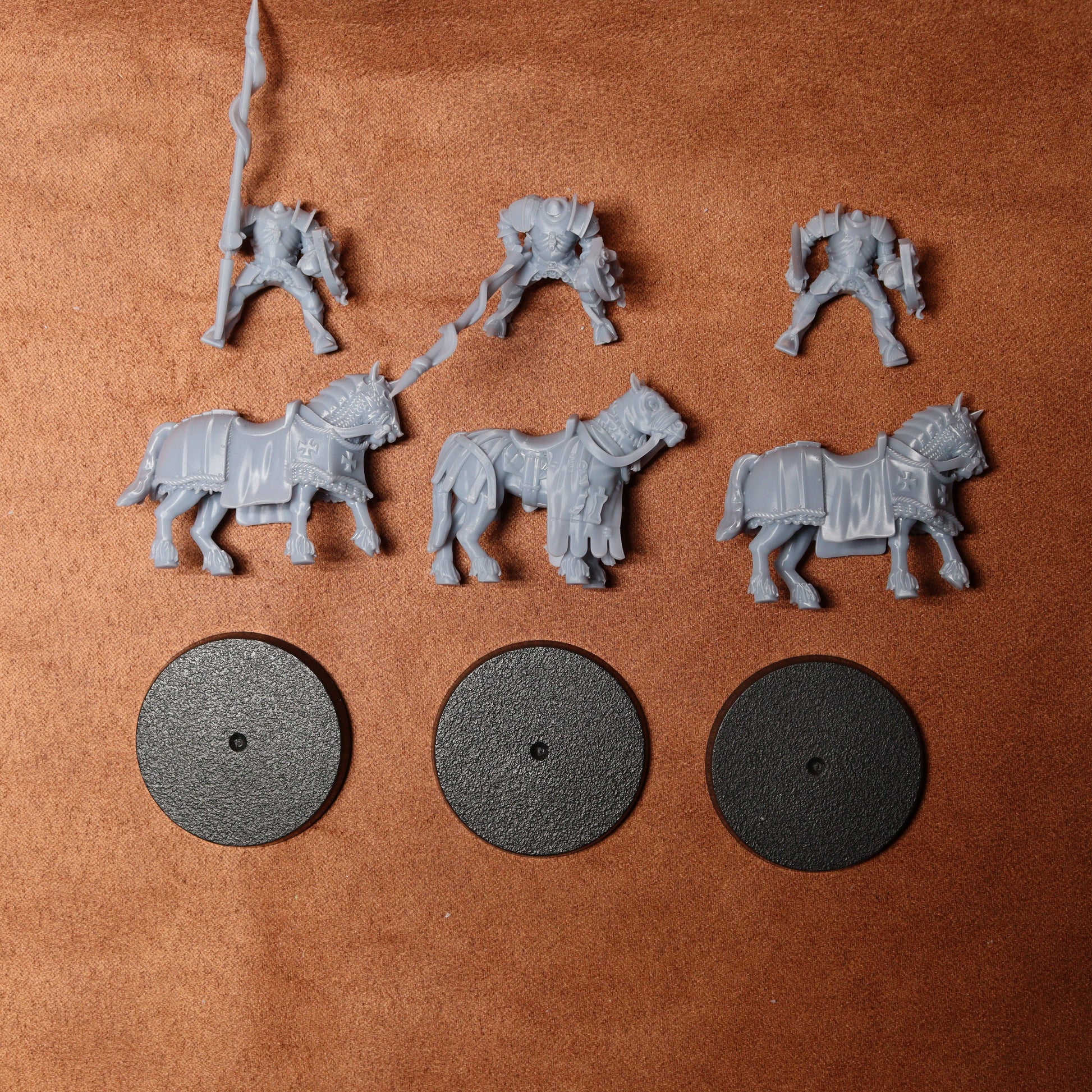 Set of gray toy figures and wheels on a brown surface