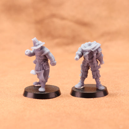 Two miniature figures on round bases against a brown background
