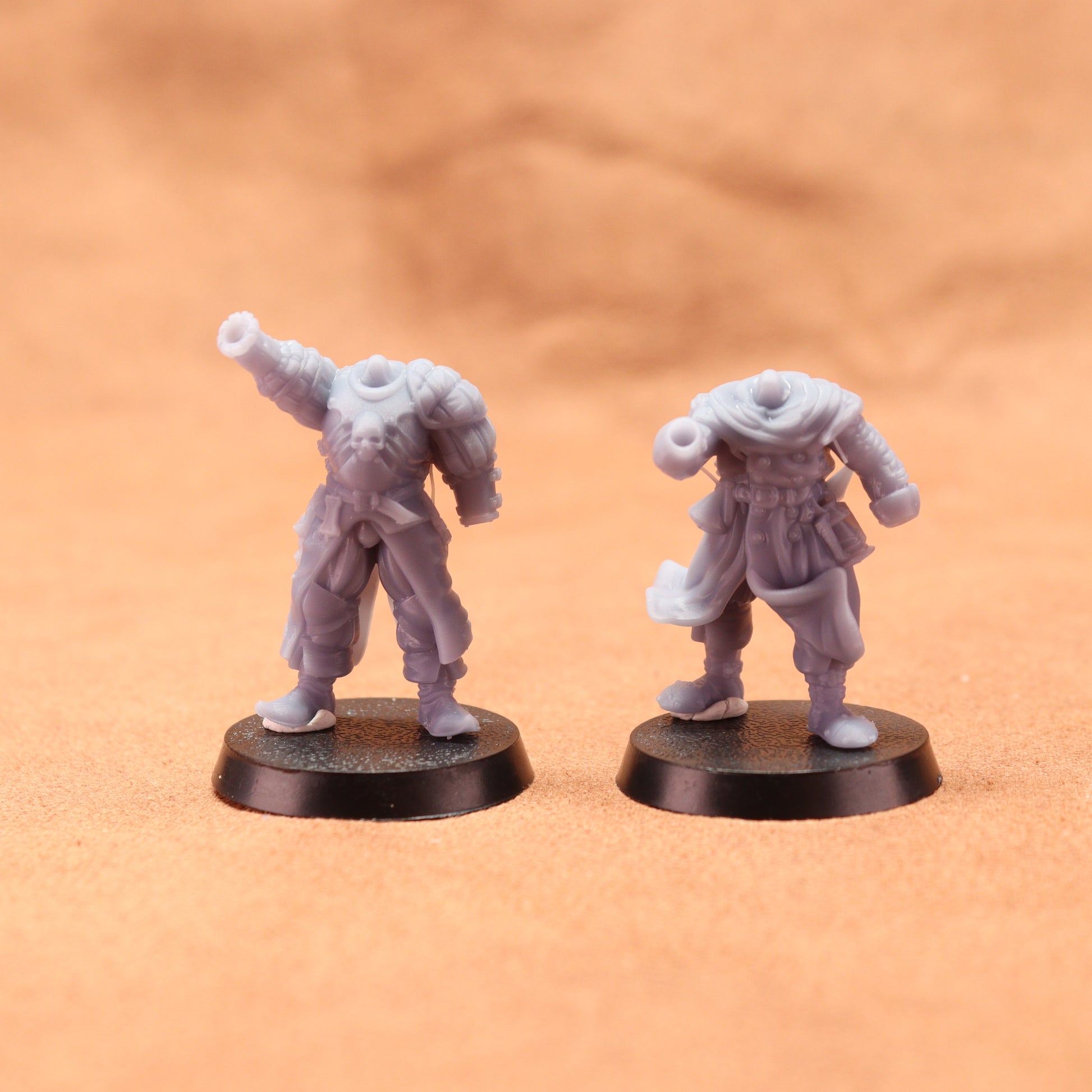 Two miniature figures on round bases against a brown background
