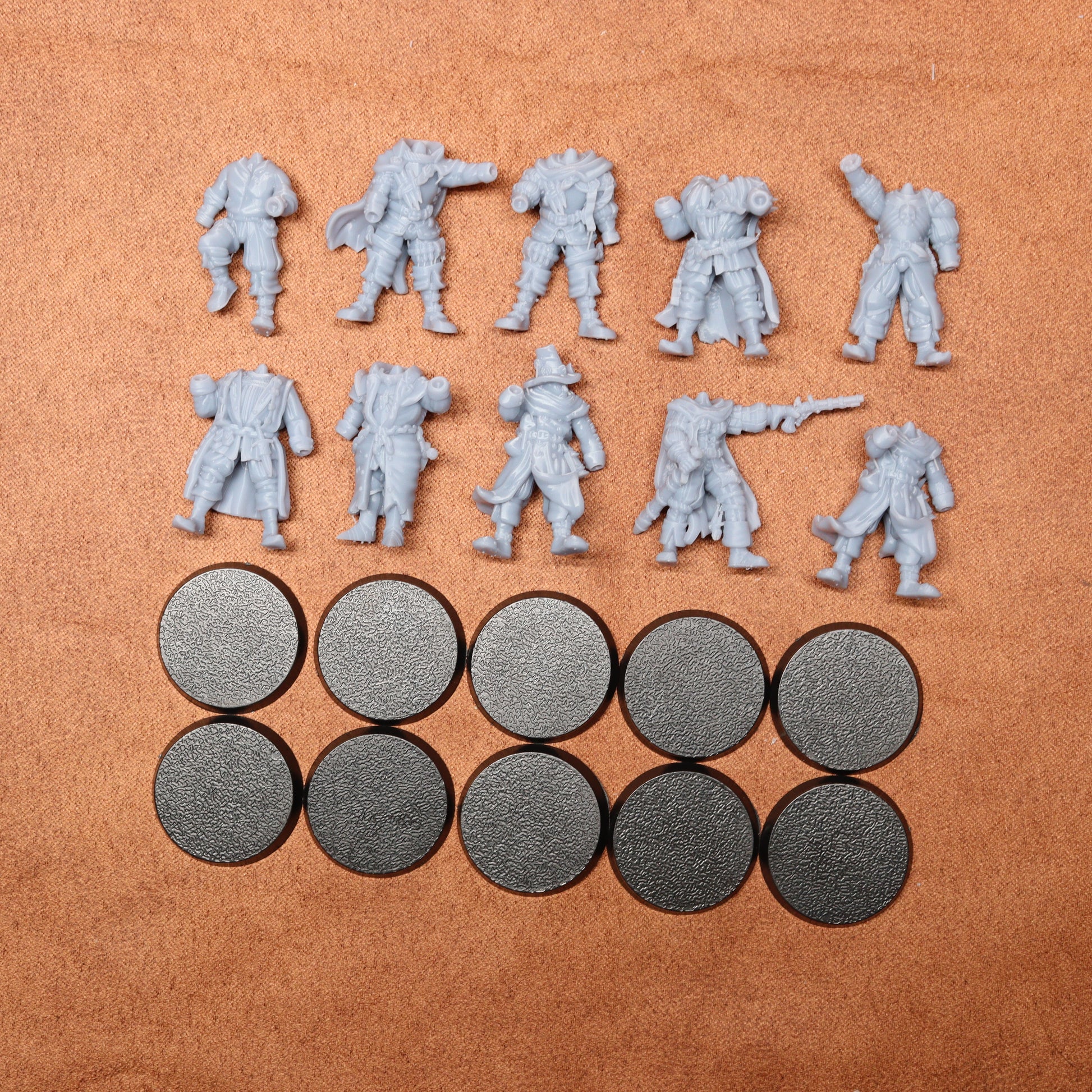 Set of gray miniature figures and round metal pieces on a brown surface