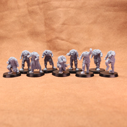 Nine gray miniature figures on black round bases against a brown leather background