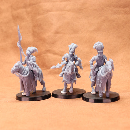 Three gray figurines on black bases against a brown background