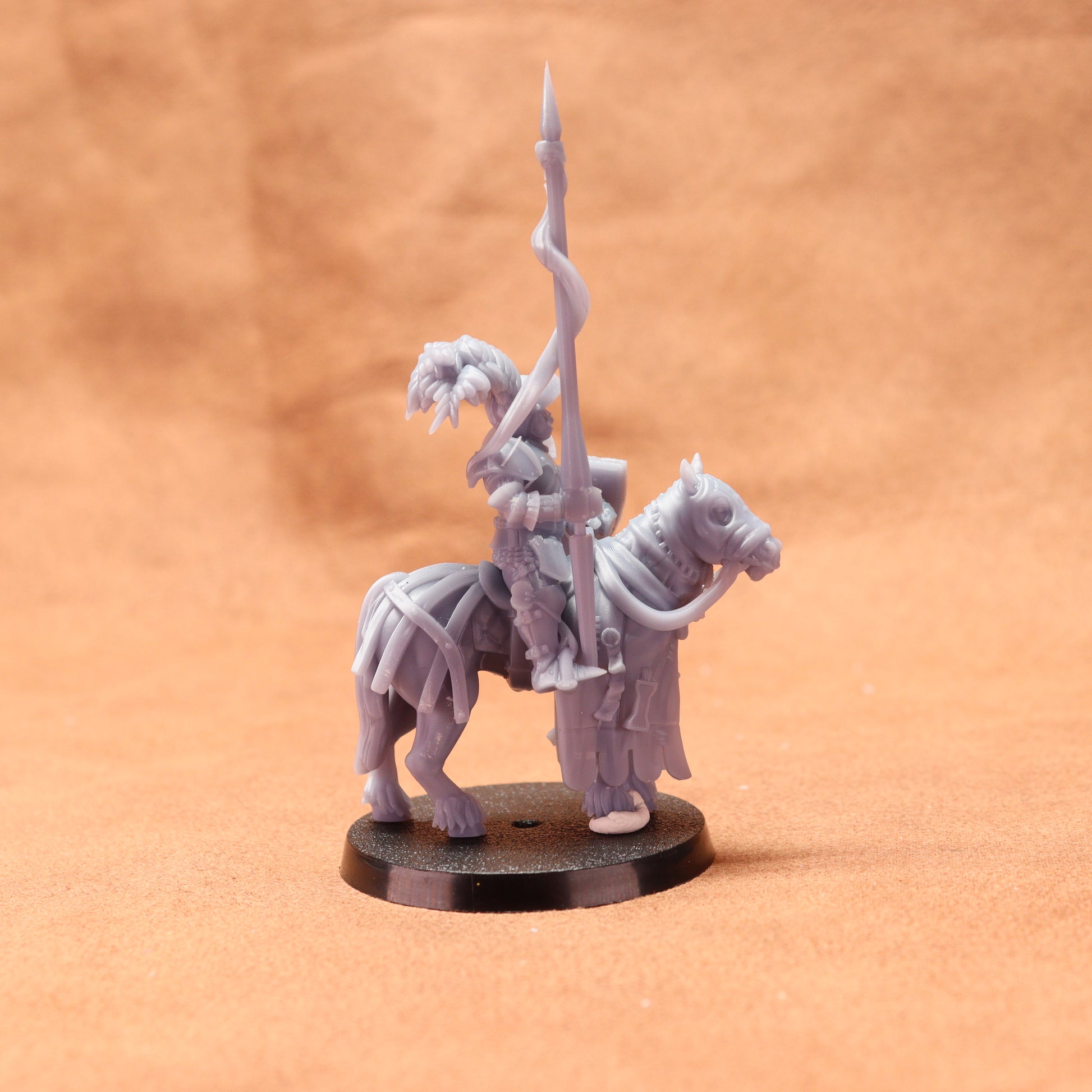 Gray figurine of a warrior on horseback with a spear on an orange background