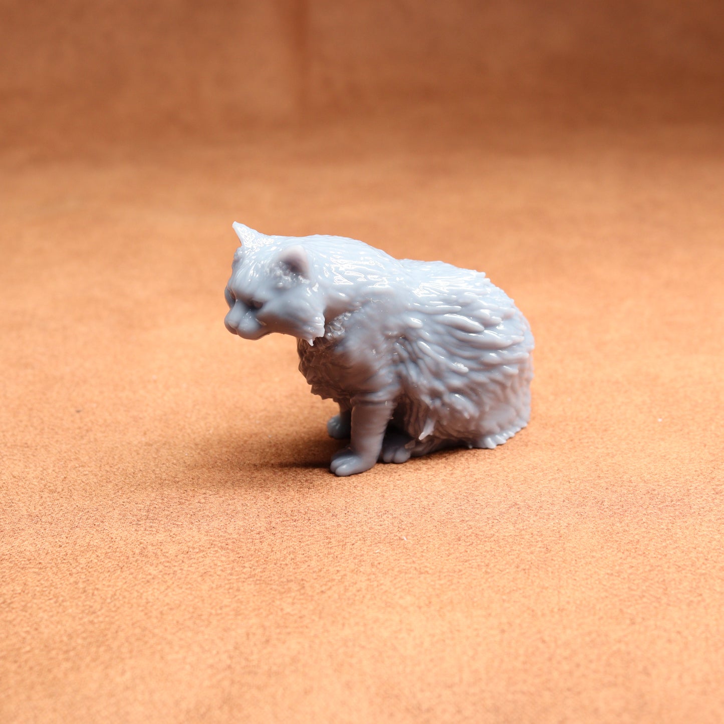 Gray cat figurine on a brown surface