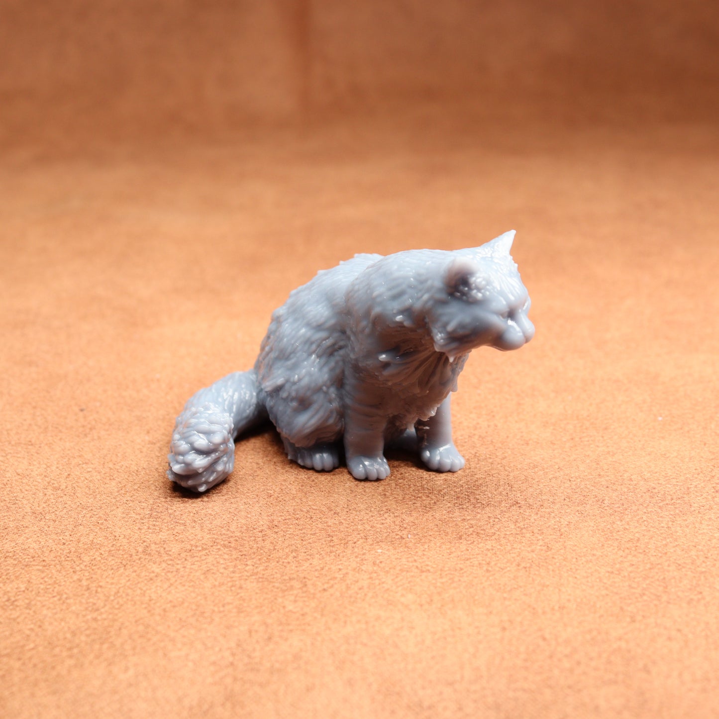 Gray cat figurine on a brown surface