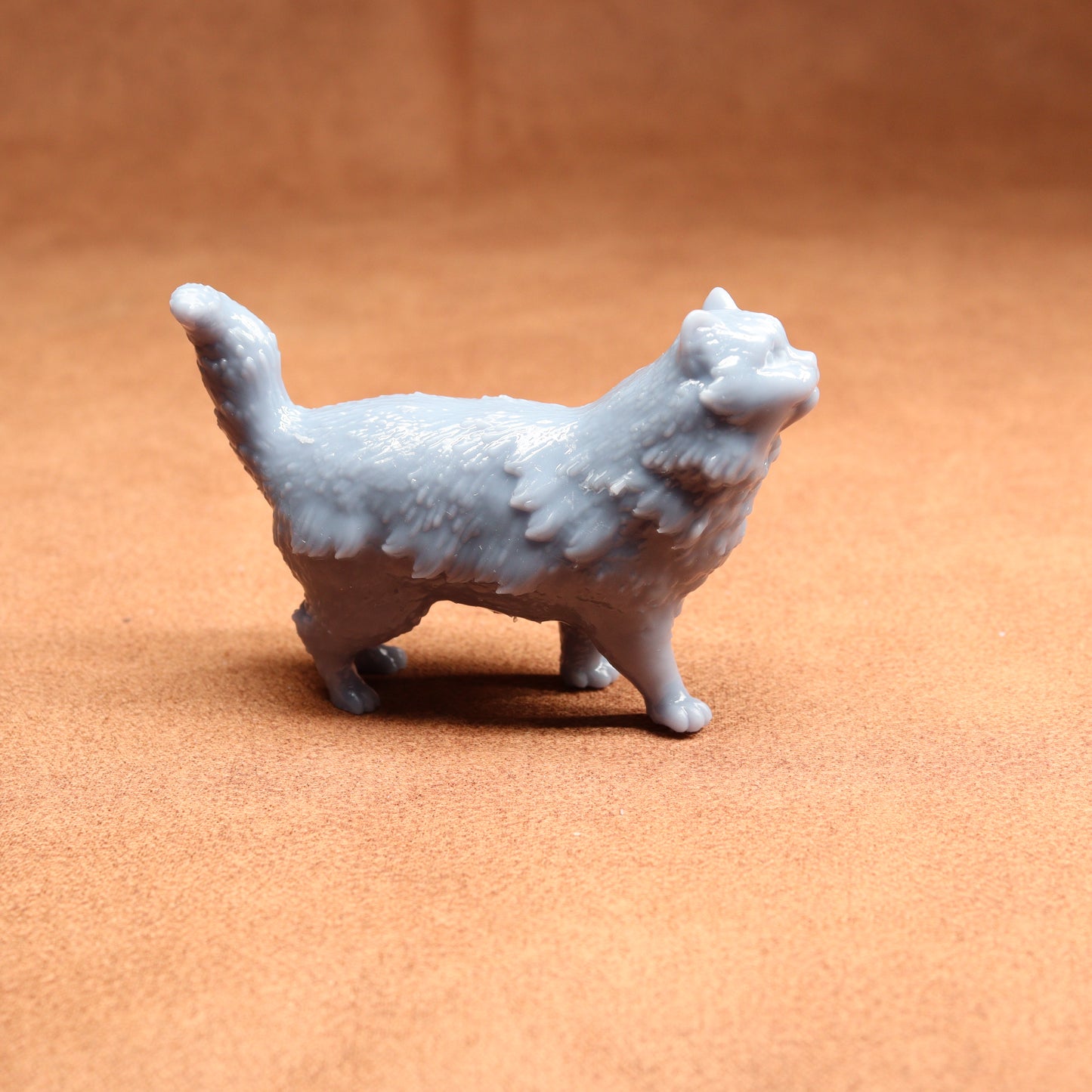 White ceramic cat figurine on a brown surface