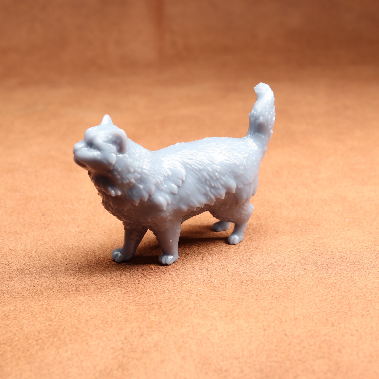 White 3D-printed cat figurine on a brown surface