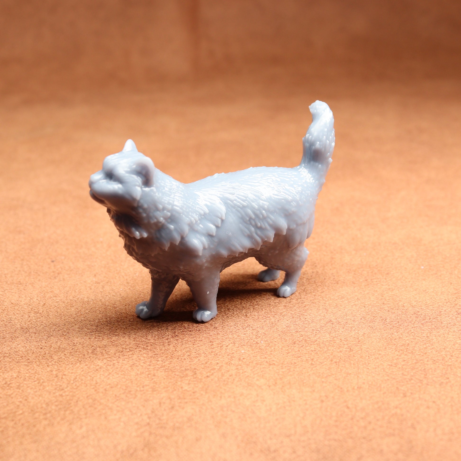 White 3D-printed cat figurine on a brown surface