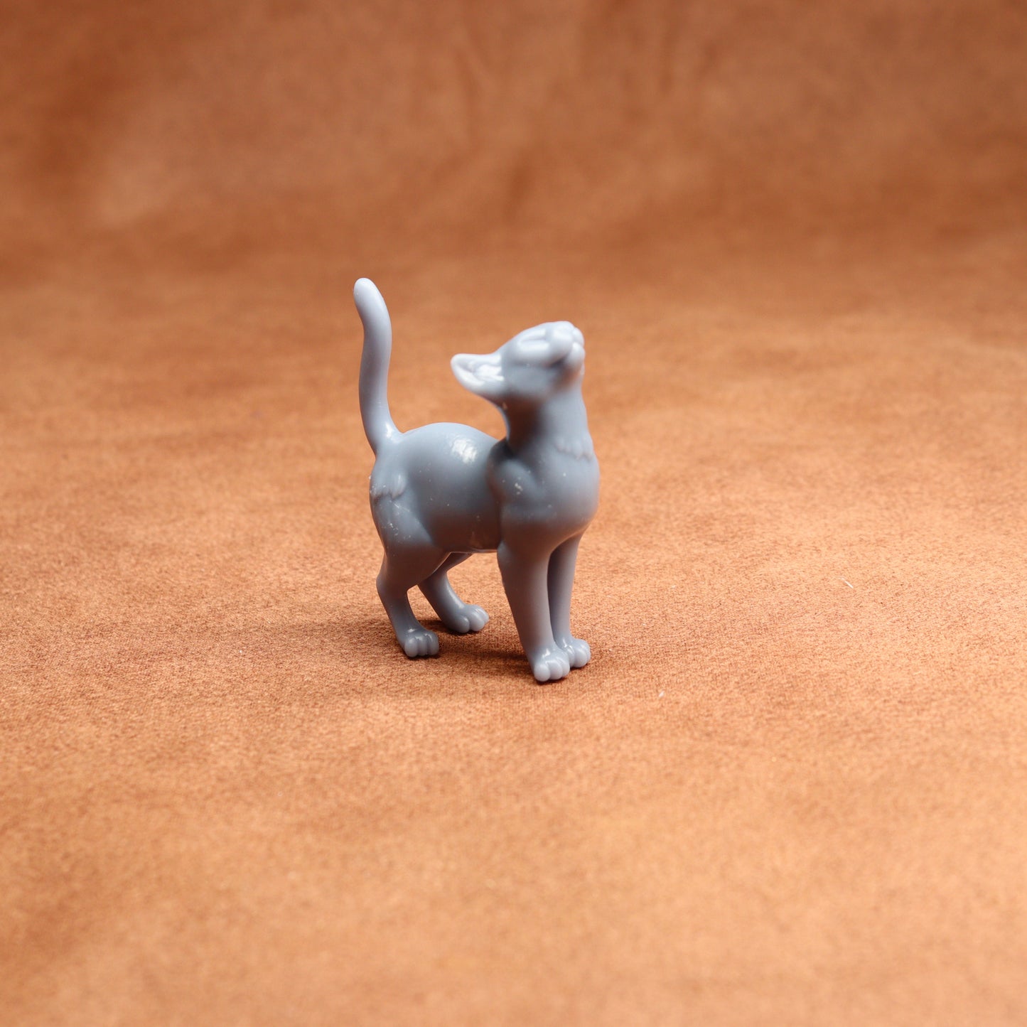 Gray cat figurine on a brown surface