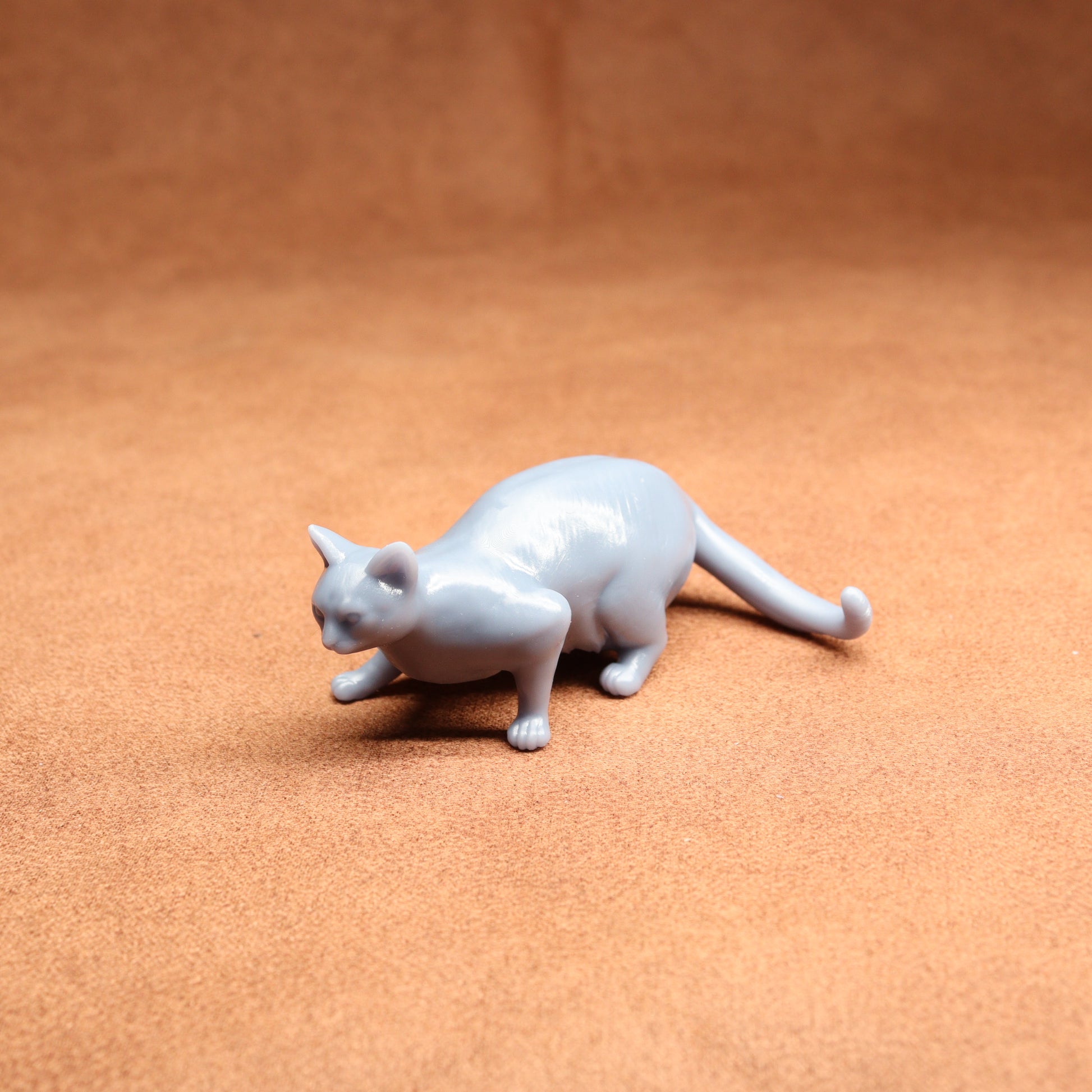 White cat figurine on a brown surface
