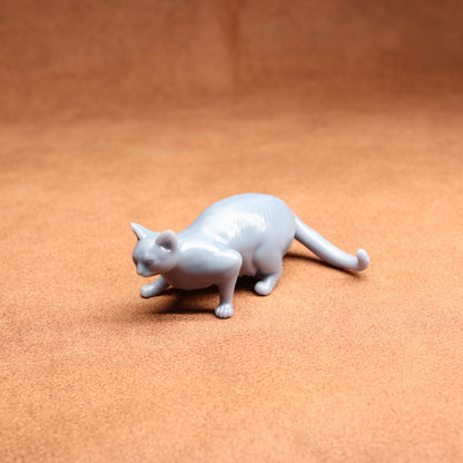 White cat figurine on a brown surface