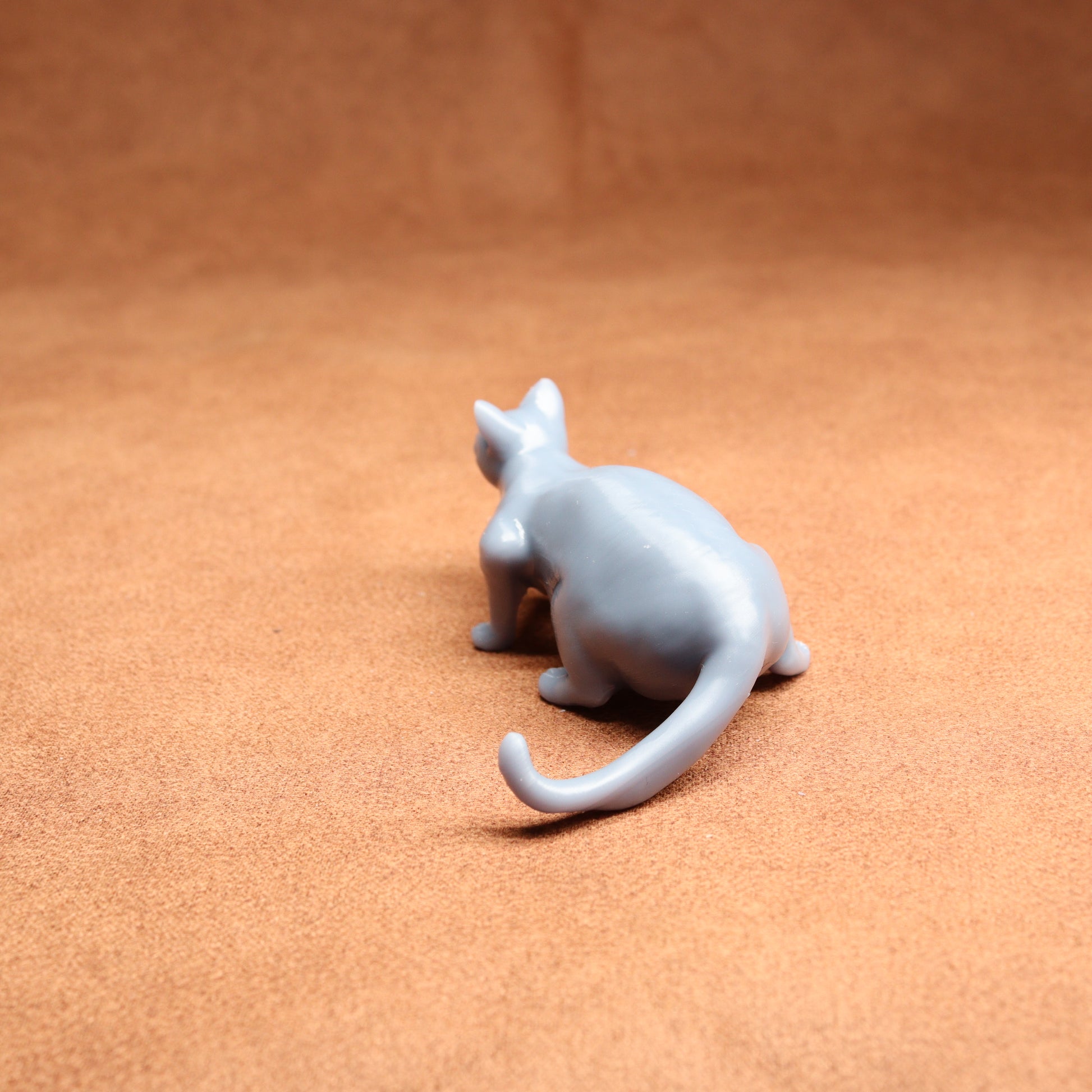 White ceramic cat figurine on a brown surface