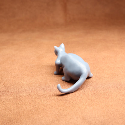 White ceramic cat figurine on a brown surface
