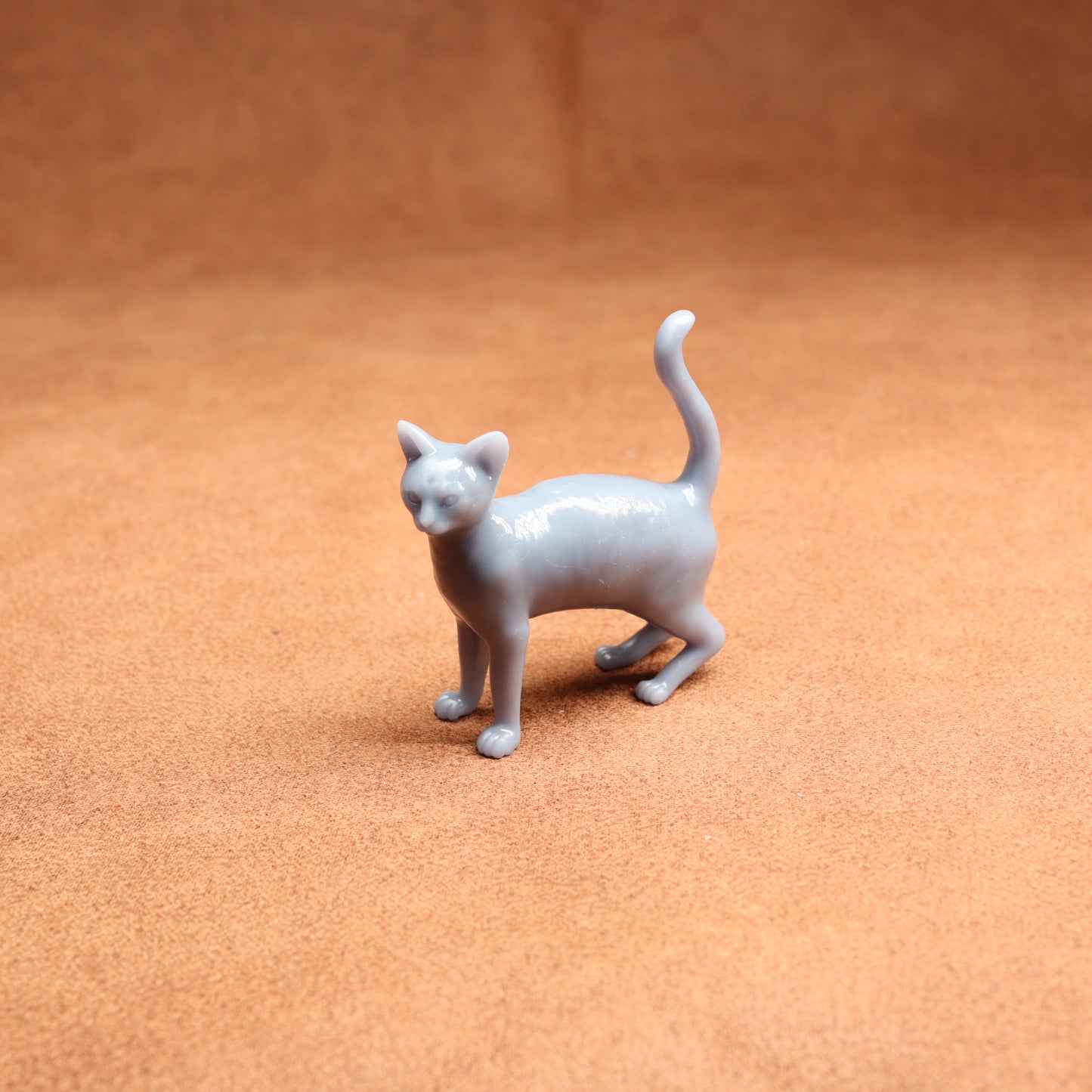 Gray cat figurine on a brown surface