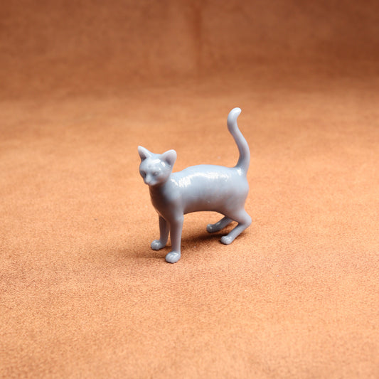 Gray cat figurine on a brown surface