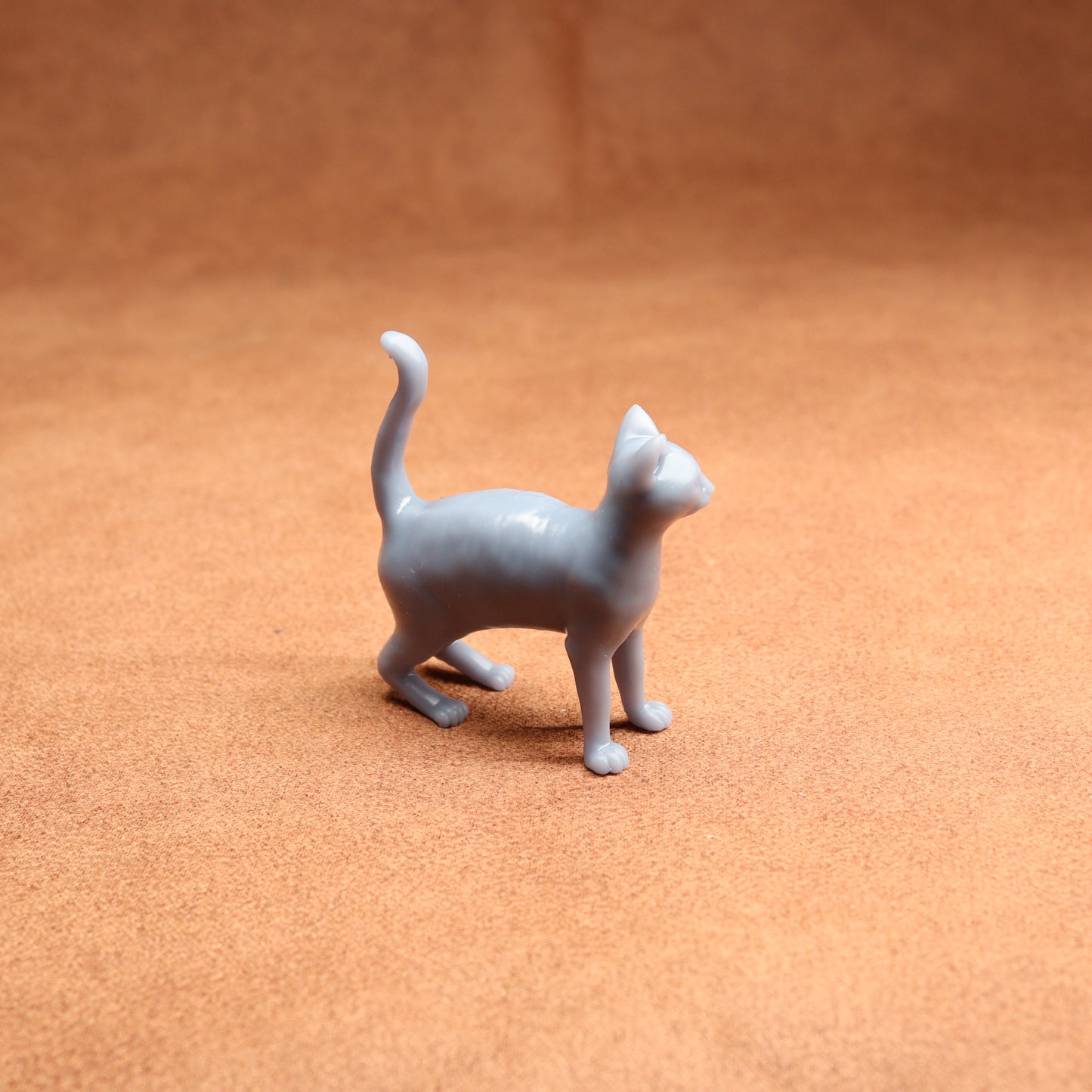 Gray cat figurine on a brown surface