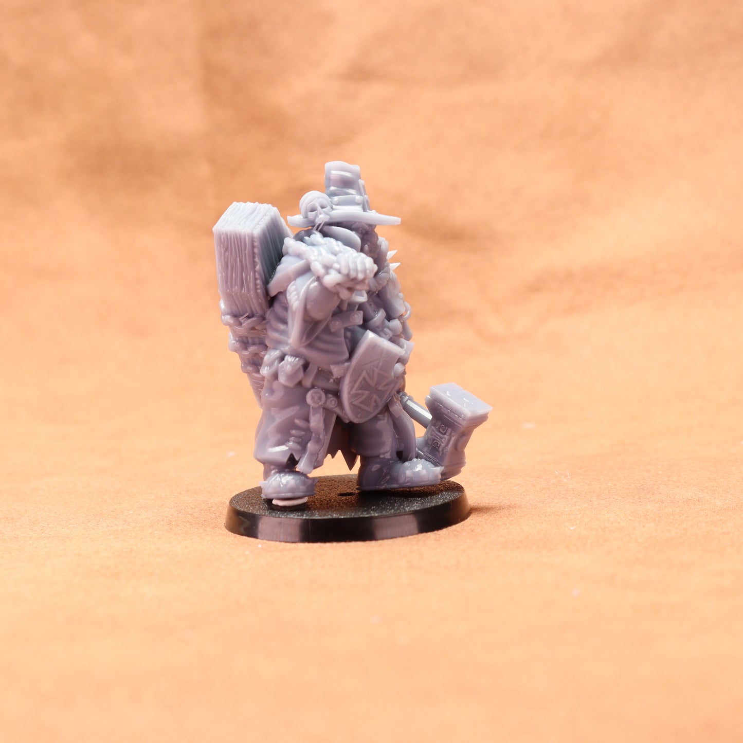 Gray miniature figure on a round base against an orange background