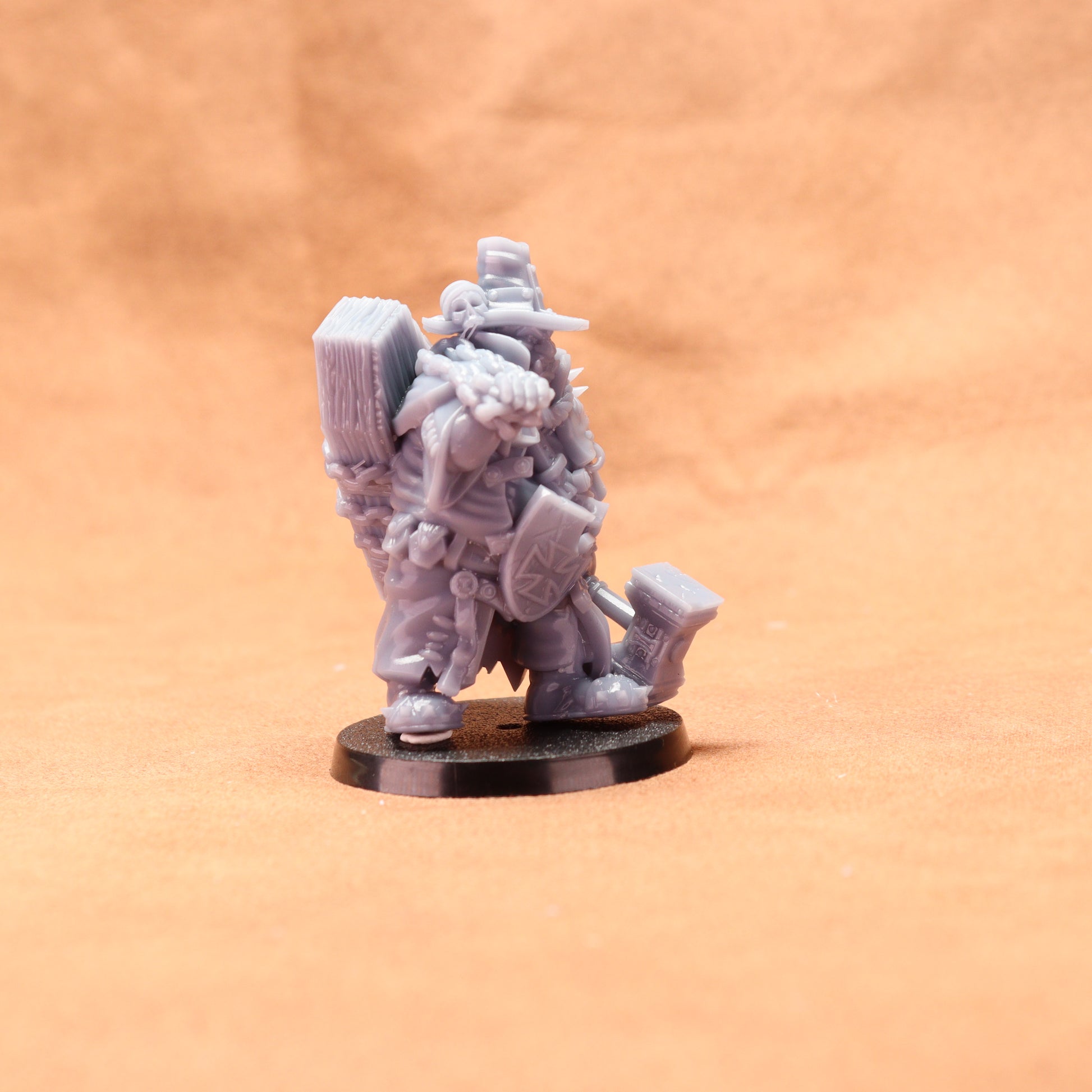 Gray miniature figure on a round base against an orange background